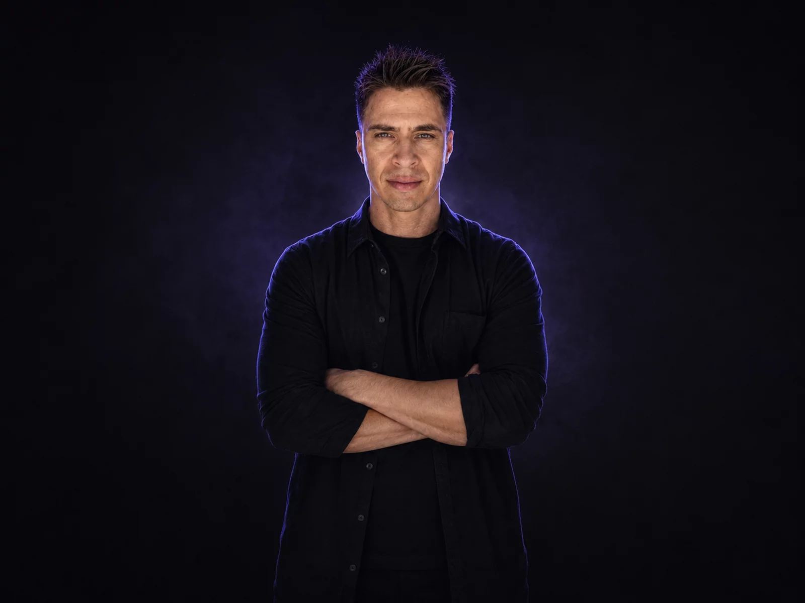 Ivan Guaderrama, arms crossed, violet studio haze
